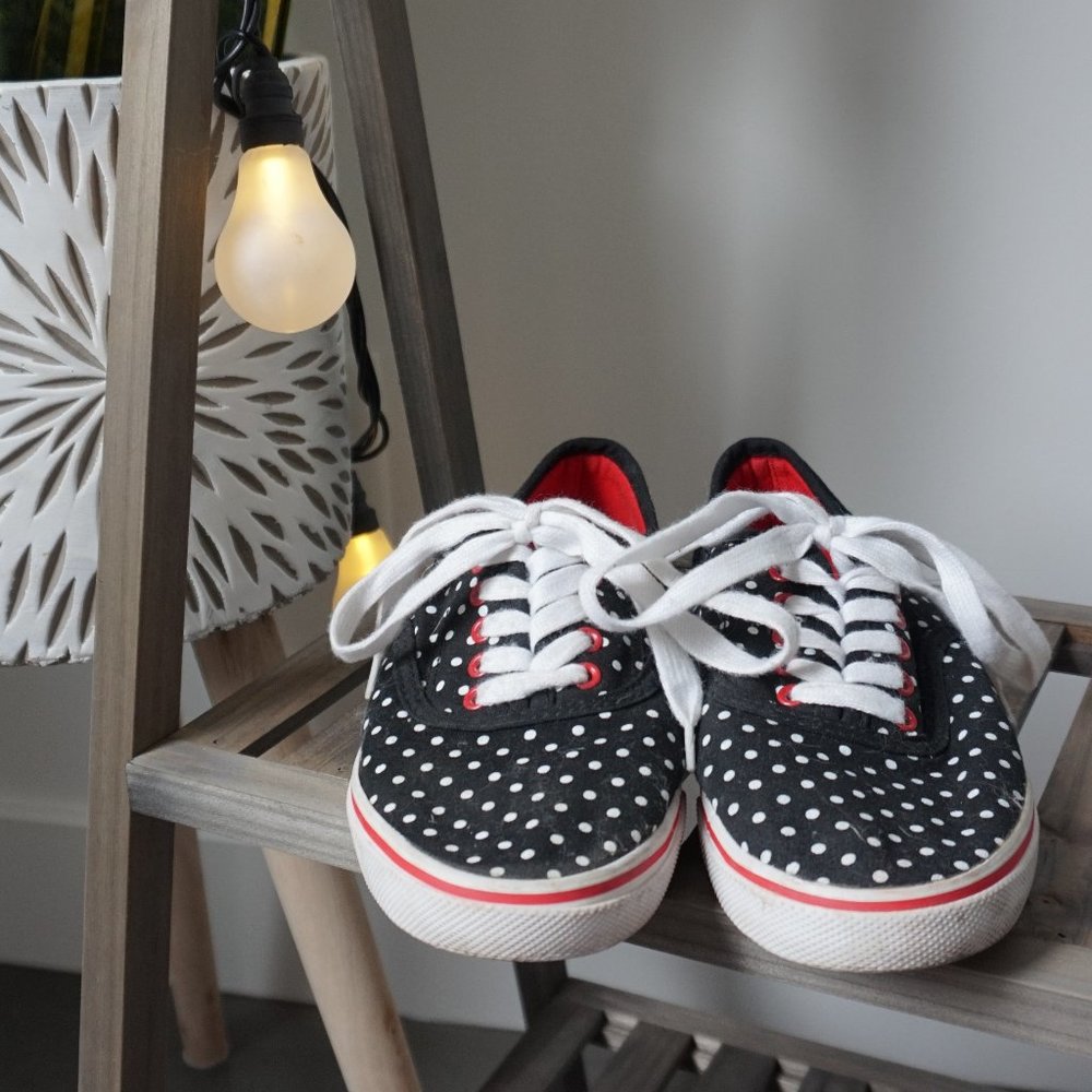 Navy blue shoe with white pimples and red accents
